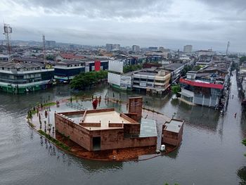High angle view of buildings by river against sky