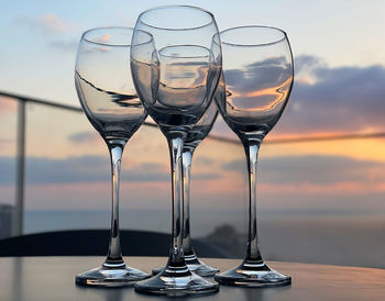 Close-up of beer in glass on table against sunset sky