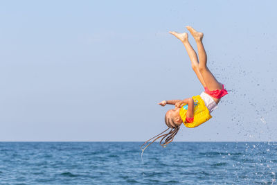 Midsection of child in sea against sky