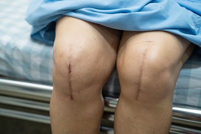 Low section of person sitting on bed