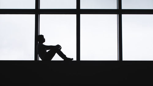 Silhouette of man against window