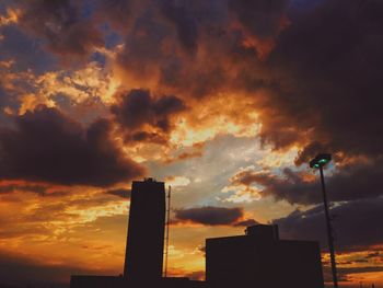 Low angle view of modern building against cloudy sky