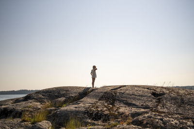 Child standing on rocky shore