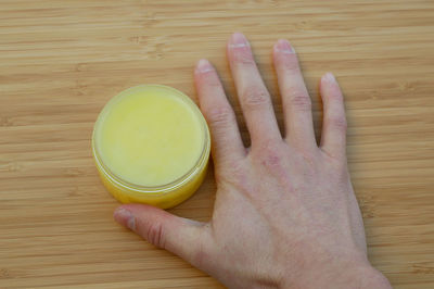 High angle view of hand holding drink on table