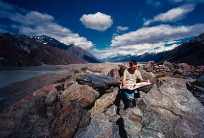 Woman standing on mountain against sky