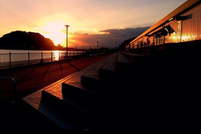 Silhouette of footbridge against sky during sunset