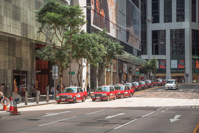 Cars on city street by buildings