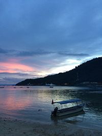 Boats in sea at sunset