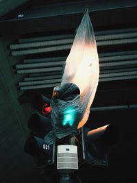 Low angle view of plastic covering road signal at night