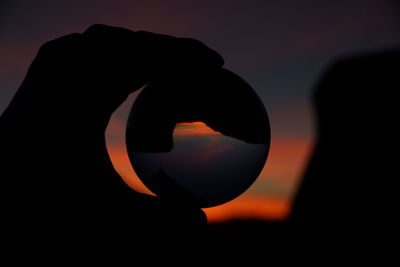 Close-up of silhouette sun against sky during sunset