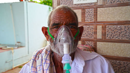 Close-up portrait of senior wearing oxygen mask