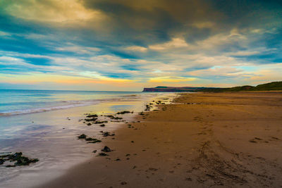 Scenic view of beach against sky during sunset