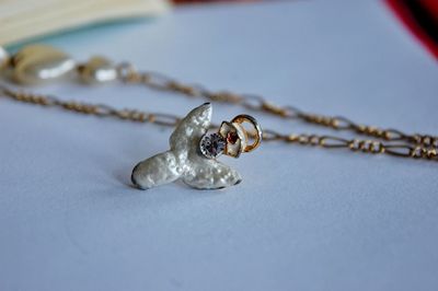 Close-up of necklace and pendant on table