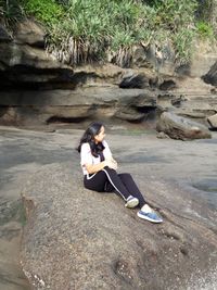 High angle view of woman sitting on rock