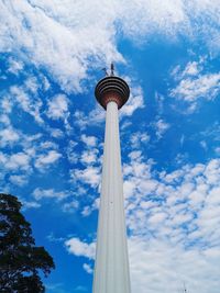 Low angle view of communications tower against cloudy sky