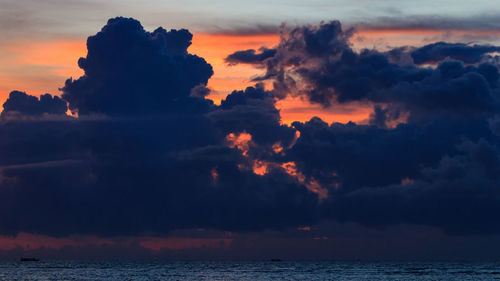 Scenic view of sea against dramatic sky during sunset