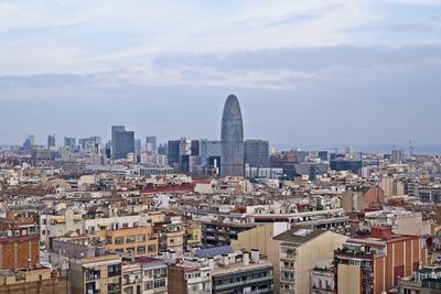 Aerial view of buildings in city against sky