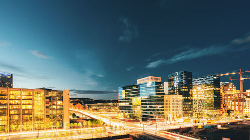 Illuminated buildings in city against sky at night