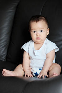 Cute baby sitting on soft sofa