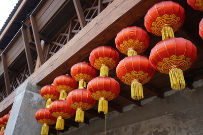 Low angle view of lanterns hanging by building