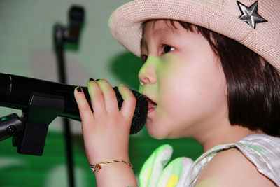 Close-up of cute girl singing into microphone