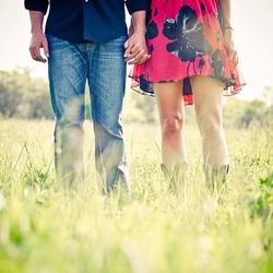 Low section of people standing on grassy field