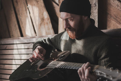 Midsection of man playing guitar