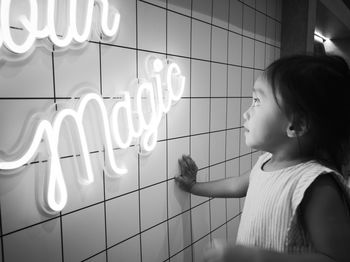 Toddler looking at the neon word magic.