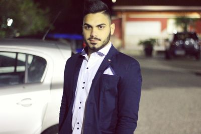 Portrait of young man standing on road