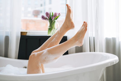 Young happy woman taking bath at home, treat yourself