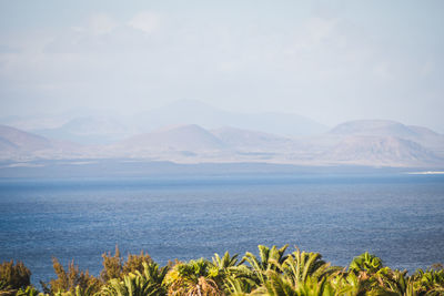 Scenic view of sea and mountains against sky