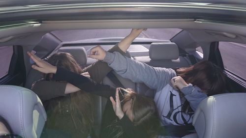 Friends dabbing while sitting in car