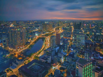 High angle view of illuminated cityscape against sky at night