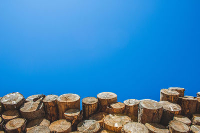 Low angle view of rocks against clear blue sky