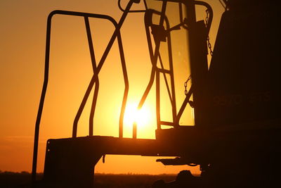 Low angle view of silhouette built structure against orange sky