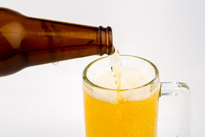 Close-up of beer glass bottle against white background