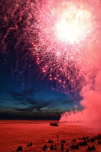Low angle view of firework display at sunset