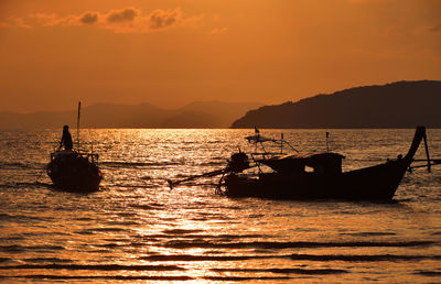 Silhouette of boat in sea at sunset