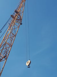 Low angle view of crane against blue sky