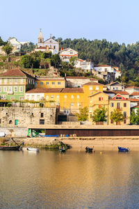 Buildings by river against sky