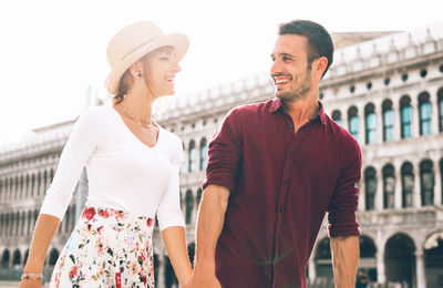 Man and woman standing against built structure