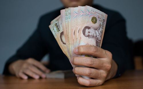 Close-up of hand holding heart shape on table