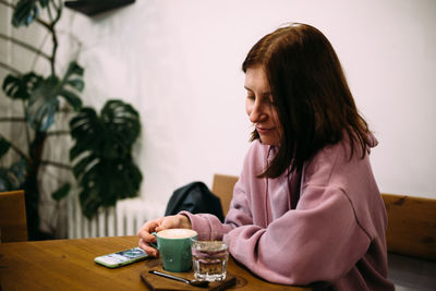 Young attractive woman in a cafe with a smartphone