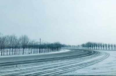 Snow covered land road against sky