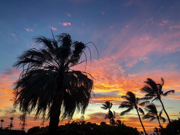 Low angle view of silhouette palm trees against romantic sky