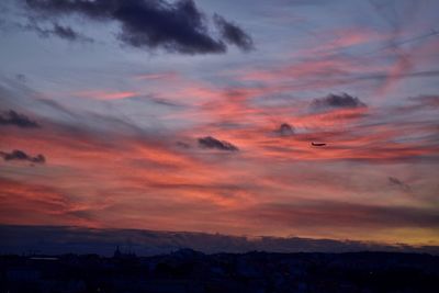 Scenic view of dramatic sky over silhouette landscape