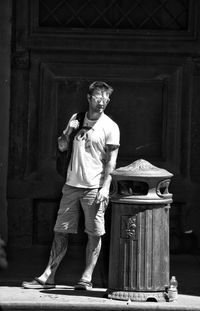 Portrait of young man standing against built structure