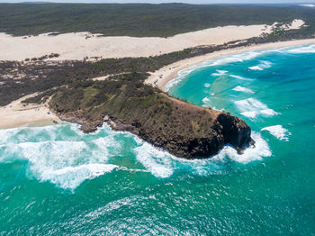 Aerial view of rock mountain by sea