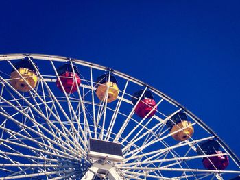 Low angle view of ferris wheel against blue sky