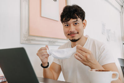 Portrait of young man using laptop